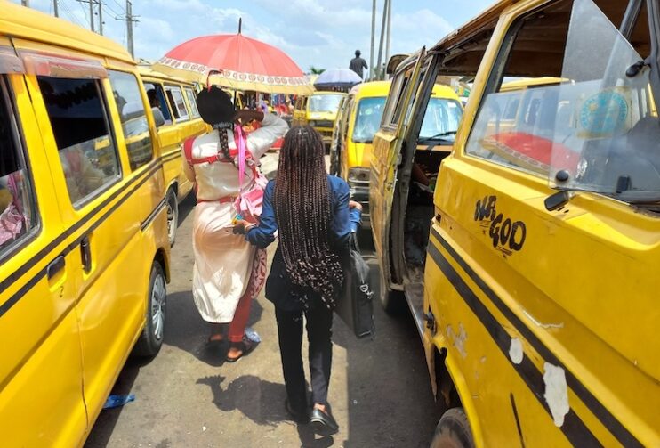 two women walking between to yellow cars.